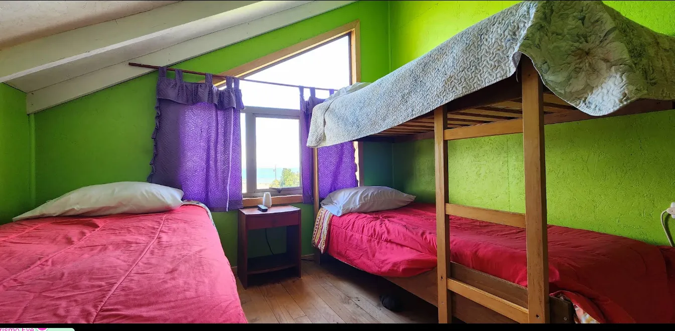 Acogedora habitación del B&B con una cama confortable y vistas al bosque y al fiordo.